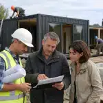 Garantie décennale container : quelles obligations pour les constructeurs et acheteurs ? Homme en casque montrant des plans à un couple
